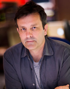 Composer Rupert Gregson-Williams looking casual in a gray t-shirt with steel-colored button-up on top.