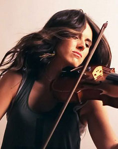 Composer Natalie Holt passionately plays the violin, her long dark hair cascading as if in a breeze