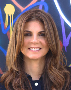 Nora Felder stands in front of a graffiti art wall