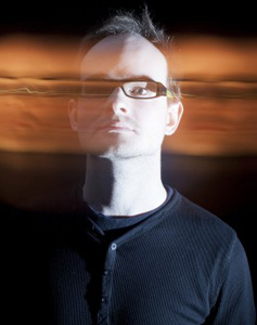 Rael Jones poses with a motion blur effect that appears to make his head move from the left to right portion of the frame.