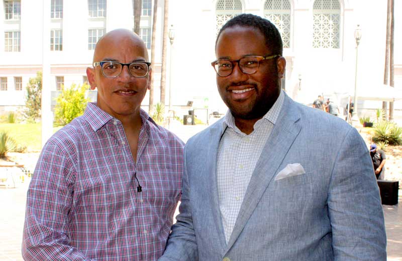 Rickey Minor and Sebastian Ridley-Thomas stand before Los Angeles' City Hall. 