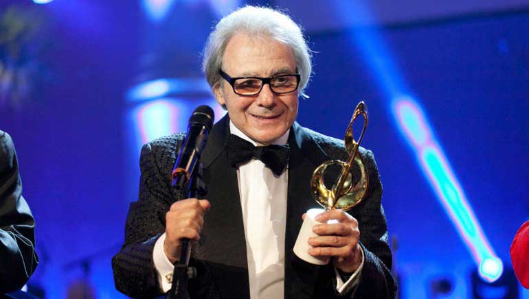 Lalo Schifren holding gold music note trophy