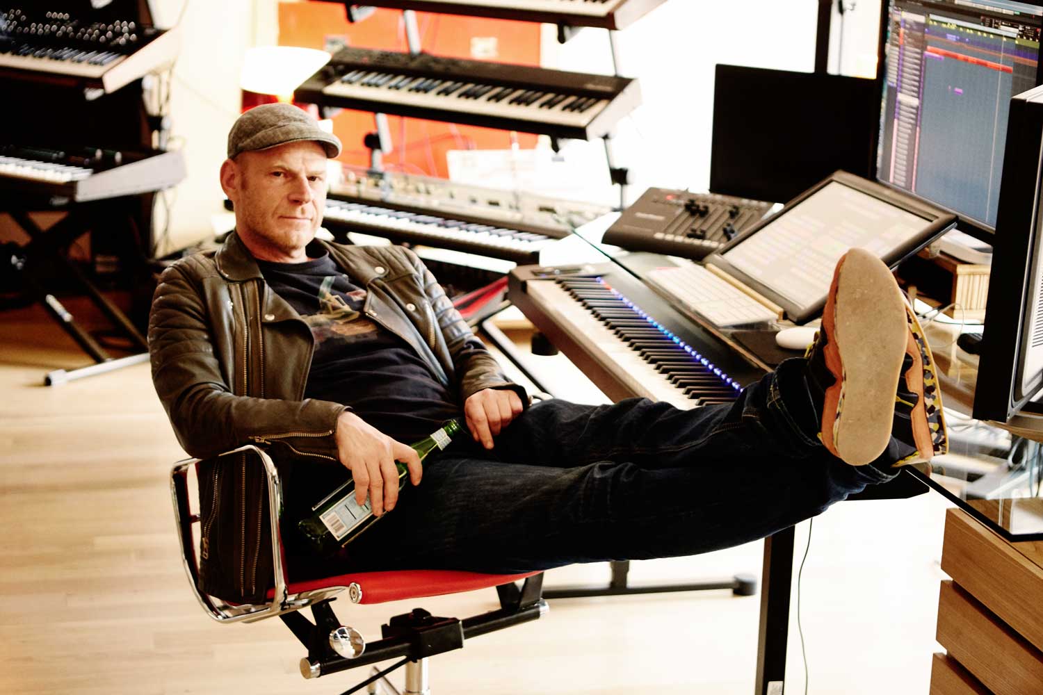 Tom Holkenborg with his feet up, at his MIDI keyboards